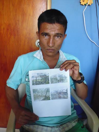 Giovanny Yamid Aldana holds a photo of his home, destroyed during a bombing by the Colombian Air Force on November 24, 2013. Photo by Dawn Paley. 